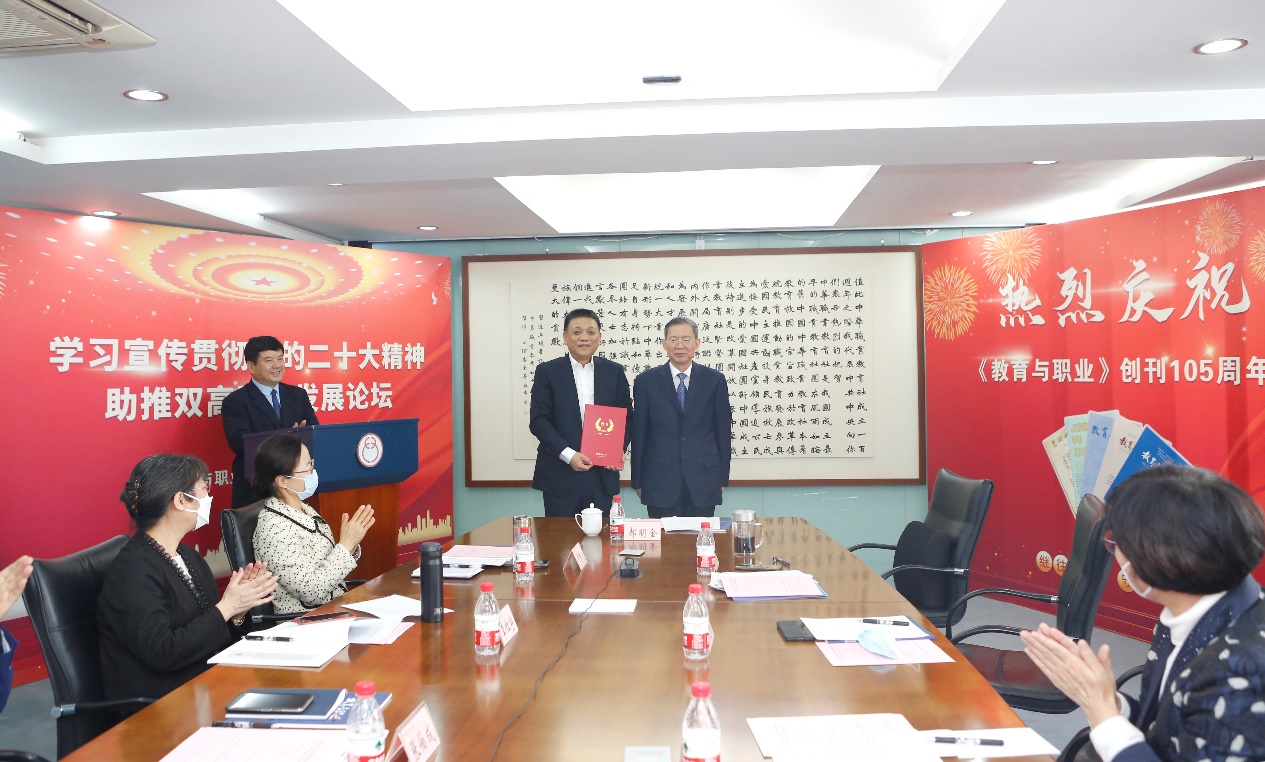 郝明金為《教育與職業(yè)》雜志編委代表陳曉明頒發(fā)聘書(shū)。中華職教社供圖