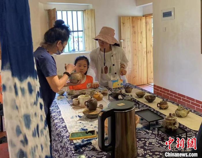 圖為：游客正在咨詢臺灣柴燒作品?！∪~秋云 攝