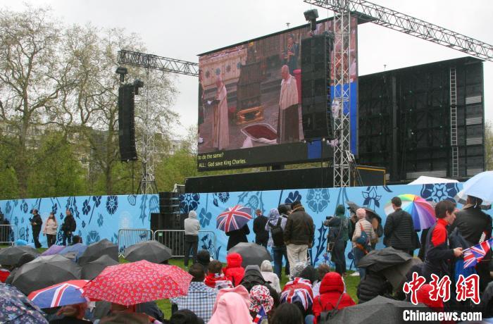 當(dāng)?shù)貢r(shí)間5月6日，英國(guó)國(guó)王查爾斯三世的加冕儀式舉行。民眾雨中觀看儀式。　歐陽(yáng)開宇 攝