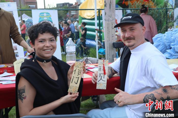 當(dāng)?shù)孛癖娫跐h字體驗(yàn)工作坊展示自己手寫(xiě)的中文名書(shū)簽?！◆斻肟鬃訉W(xué)院供圖