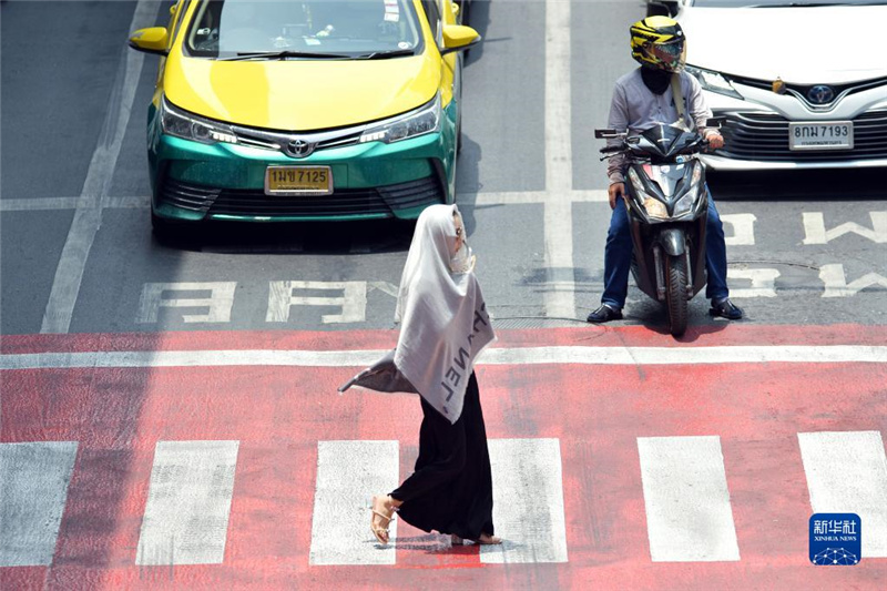 5月17日，行人在泰國曼谷街頭用圍巾遮陽。新華社發(fā)（拉亨攝）