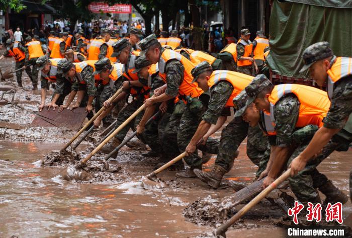 7月4日，萬州區(qū)五橋街道，武警官兵清理街道上的淤泥。　冉孟軍 攝