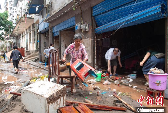 7月4日，萬州區(qū)五橋街道，洪水退去后，居民搶救生活物資?！∪矫宪?攝