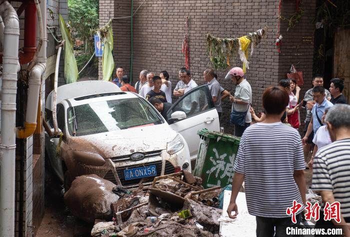7月4日，萬州區(qū)五橋街道，居民救援受困的私家車。　冉孟軍 攝