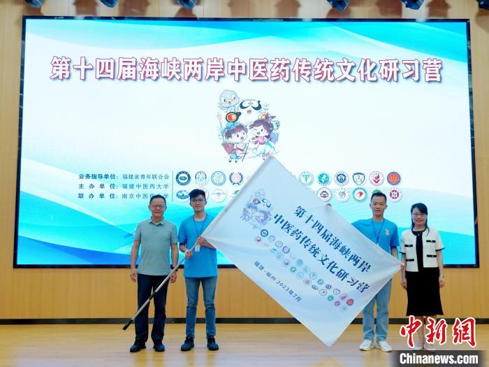 共青團(tuán)福建省委副書記吳雪(右一)、福建中醫(yī)藥大學(xué)黨委副書記林羽(左一)為兩岸學(xué)生代表頒授營旗?！≡S燁婷 攝