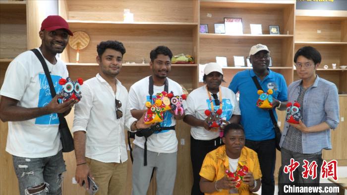 圖為國(guó)際青年代表展示親手制作的東營(yíng)非遺黃河口布偶 。　齊魯 攝