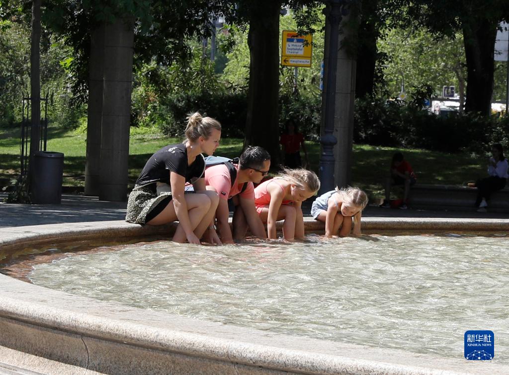 7月8日，人們在德國法蘭克福的一處噴泉玩水。近日，德國法蘭克福逐漸迎來暑熱天氣。新華社記者 張帆 攝