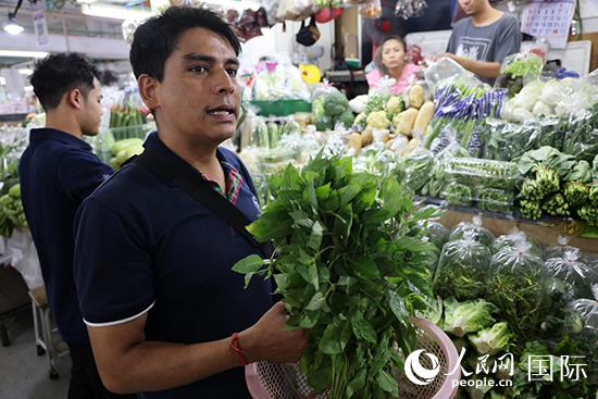 7月19日，泰國曼谷藍(lán)象餐廳員工向參加活動(dòng)的多國代表介紹如何挑選新鮮蔬菜。 人民網(wǎng)記者 張矜若攝