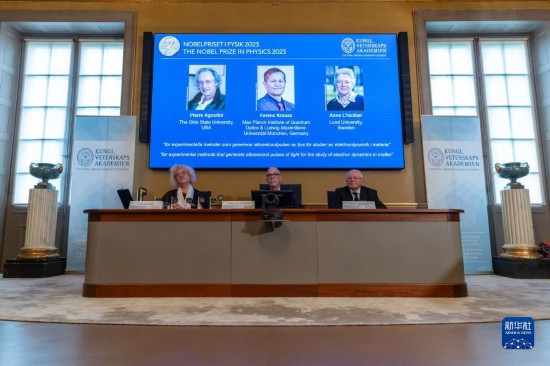 10月3日，在瑞典斯德哥爾摩舉行的2023年諾貝爾物理學獎公布現場，屏幕上顯示獎項得主皮埃爾·阿戈斯蒂尼（左）、費倫茨·克勞斯（中）和安妮·呂利耶的照片。新華社發(fā)（魏學超攝）