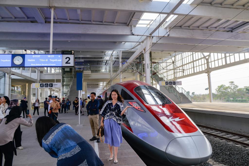 10月17日，在印度尼西亞萬隆德卡魯爾站，乘客在站臺上和雅萬高鐵高速動車組列車合影。