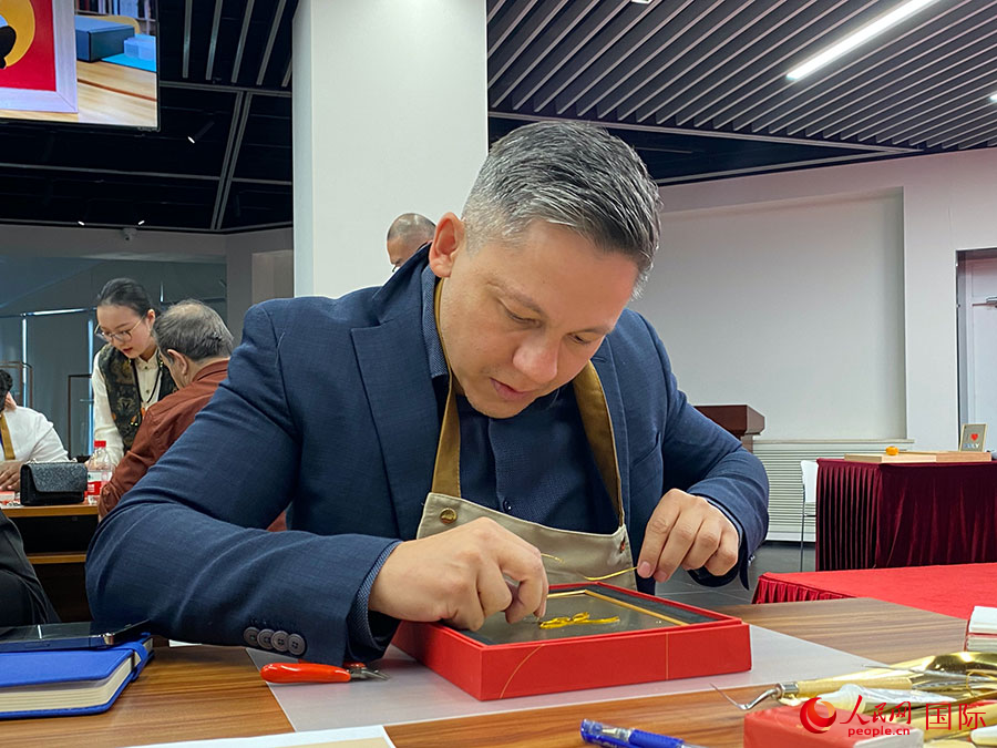 2023“一帶一路”媒體合作論壇聯(lián)合采訪團團員，親身體驗景泰藍(lán)工藝。人民網(wǎng)記者 于洋攝