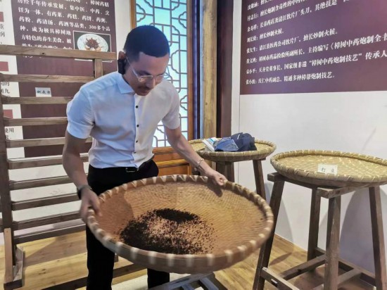 2023“一帶一路”媒體合作論壇聯(lián)合采訪團(tuán)團(tuán)員在非遺文化展示館體驗(yàn)中藥炮制技藝。（本報(bào)記者 黃超攝）