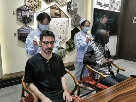 2023“一帶一路”媒體合作論壇聯(lián)合采訪團(tuán)團(tuán)員在九牛草展示館體驗(yàn)艾灸。（本報(bào)記者 黃超攝）