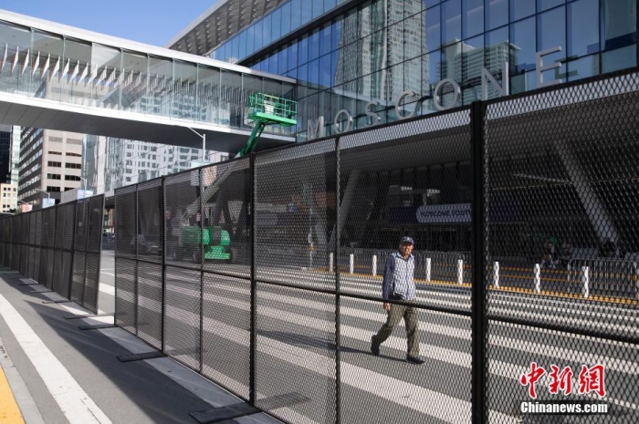當?shù)貢r間11月10日，一名行人從美國舊金山莫斯康中心周圍的金屬圍欄旁經(jīng)過。隨著亞太經(jīng)合組織(APEC)第三十次領(lǐng)導(dǎo)人非正式會議臨近，作為會議場地的莫斯康中心附近出現(xiàn)金屬圍欄，執(zhí)勤警察也大幅增加。<a target='_blank' href='/'><p  align=