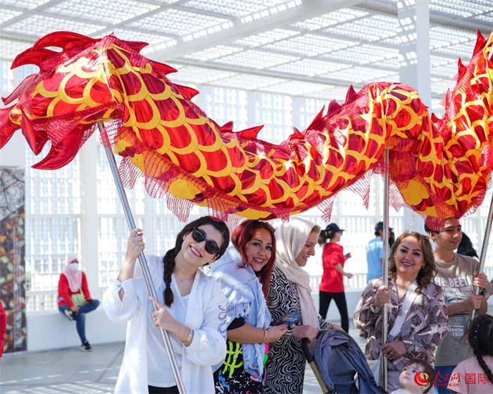 游客體驗(yàn)舞龍。 人民網(wǎng) 塔里克·易卜拉欣攝