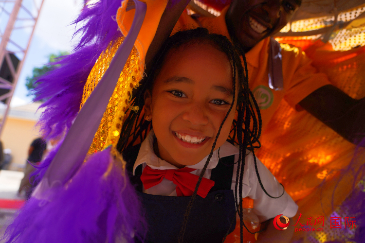 一名小朋友在與舞獅表演者互動(dòng)。人民網(wǎng)記者 黃煒鑫攝