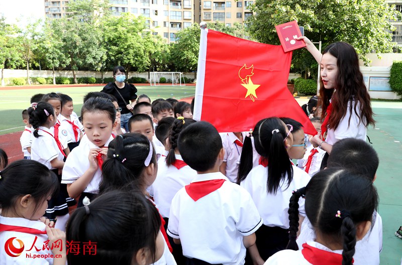 老師向少先隊員展示隊旗。人民網(wǎng) 符武平攝
