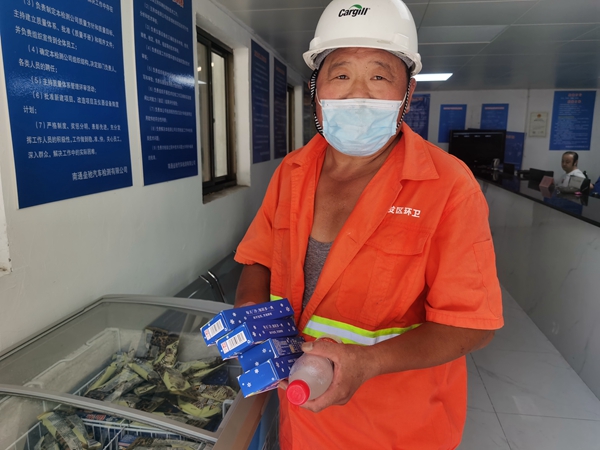 1環(huán)衛(wèi)工倪建宏小憩后，為還同事帶去冷飲。人民網(wǎng)記者王繼亮攝