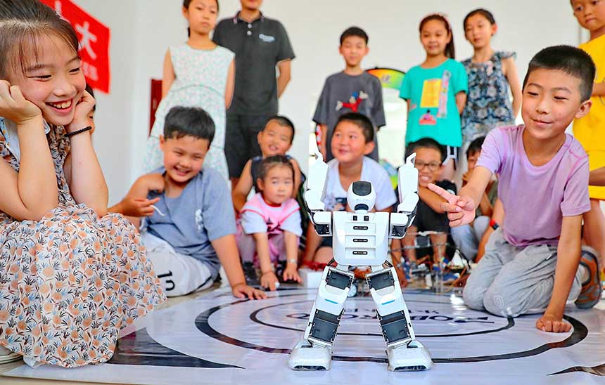 2022年7月19日，河北省秦皇島市海港區(qū)白塔嶺街道秦皇半島第二社區(qū)內(nèi)，小朋友正在觀看“機(jī)器人跳舞”。 曹建雄攝