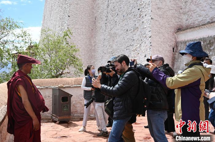 圖為中外媒體拍攝朝拜布達拉宮的僧人?！≮w朗 攝