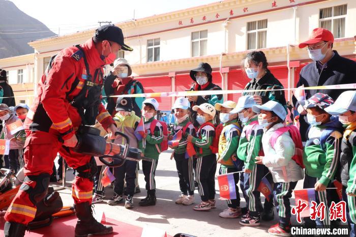 圖為消防指戰(zhàn)員為學(xué)生講解、演示先進(jìn)救援裝備。　趙琳 攝
