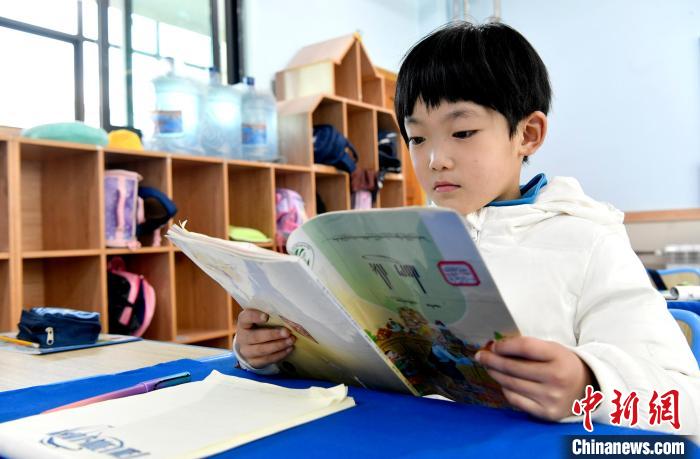 3月14日，西藏拉薩市第一小學(xué)一年級(jí)六班學(xué)生丁增樂吉在閱讀藏語課本。　李林 攝