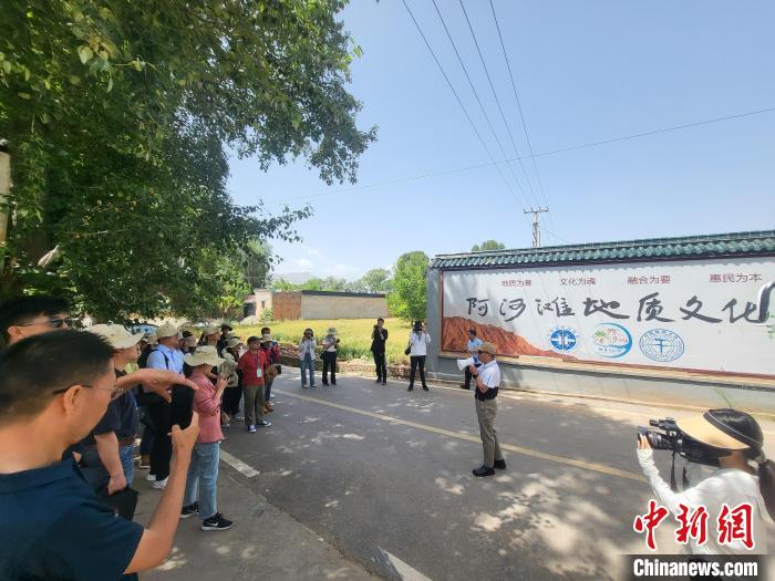 圖為中國地質(zhì)大學(xué)(北京)教授張緒教介紹村落情況?！『衍?攝