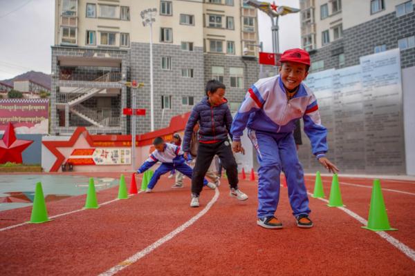 在高原上教孩子們打手球，“慢慢兒來，甭著急！”