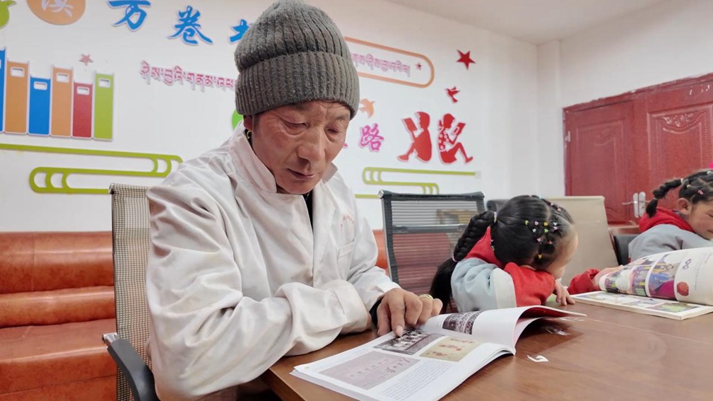 一位當(dāng)?shù)卮迕窈秃⒆觽冊谀良視堇锉M情享受閱讀時光。申扎縣融媒體中心供圖