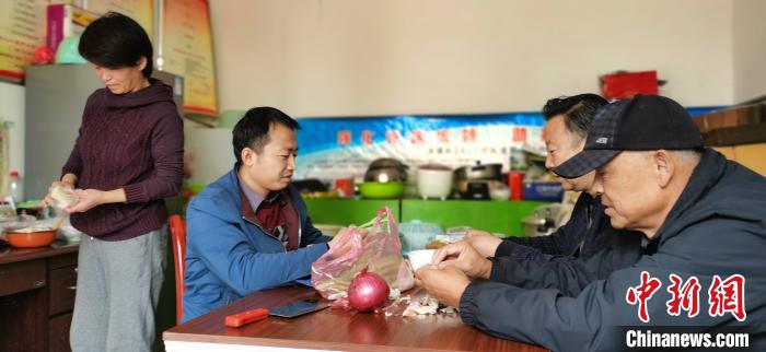 圖為扶貧路上“臨時(shí)一家人”準(zhǔn)備午餐。　魏建軍 攝