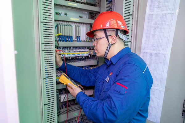 呂曉勇在保護(hù)盤柜前檢查二次回路接線情況。受訪者供圖
