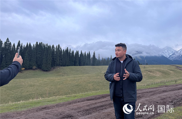 在庫爾德寧，吾買爾江被雪山美景震撼，即興錄制了短視頻作品。人民網(wǎng)記者曾書柔攝