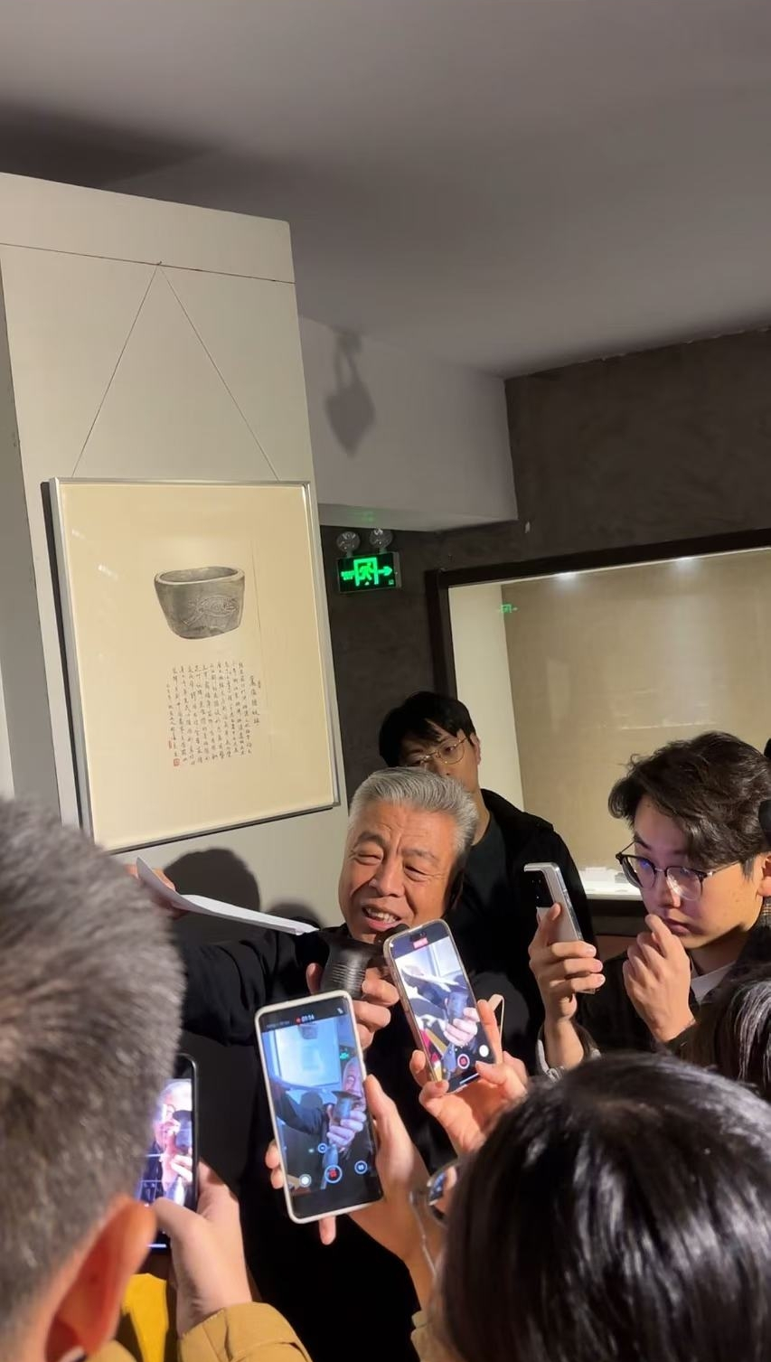 黑陶邢文化博物館館長邢葆東展示兩張相疊的A4紙，向記者解釋此為杯口的厚度。