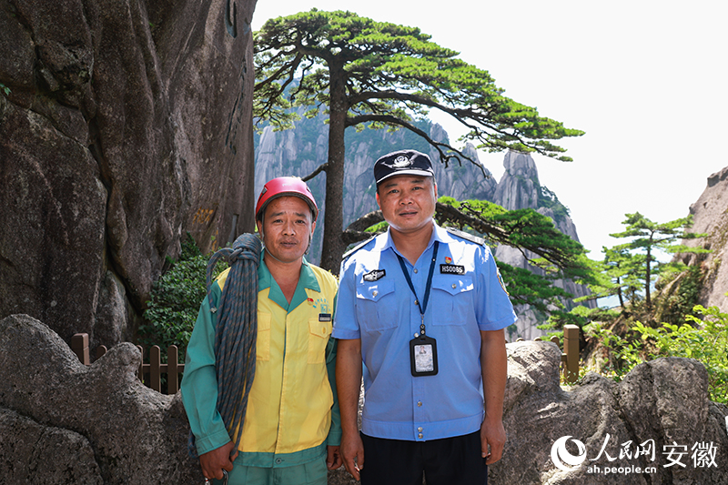 全國道德模范李培生（左）和胡曉春在迎客松前合影。人民網(wǎng)記者 張俊攝