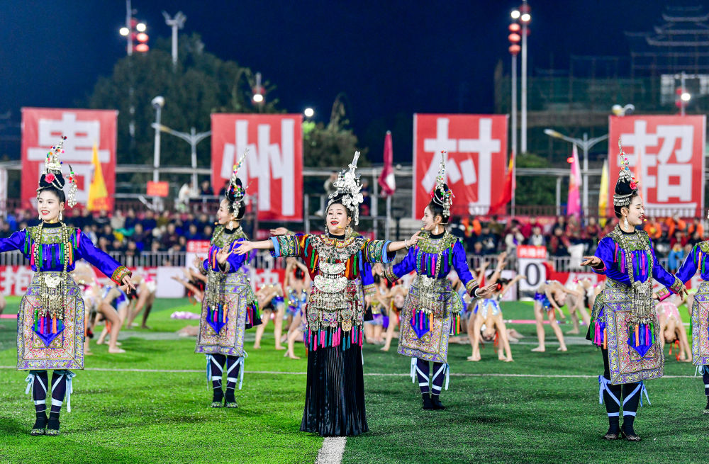 2025年3月14日，2025年貴州“村超”40強(qiáng)交叉賽在榕江“村超”足球場舉行，演員在比賽間隙表演侗族大歌，民族文化伴隨著體育賽事成功“出圈”。圖片來源：新華社