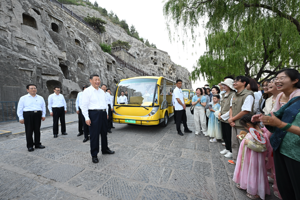 5月19日，習(xí)近平在洛陽龍門石窟考察時，同游客親切交流。