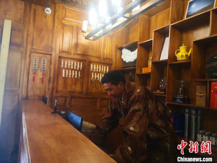 圖為桑杰才讓用電腦處理財(cái)務(wù)?！∈缝o靜 攝