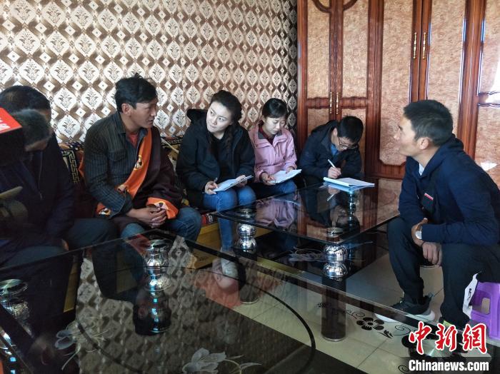 圖為調(diào)查組工作人員正在入戶調(diào)查。　祁增蓓 攝