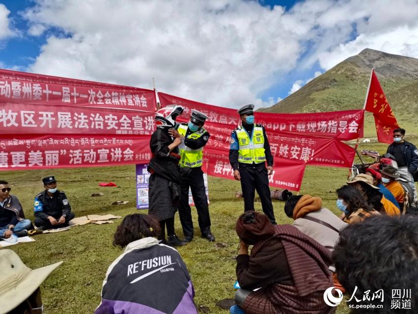 給牧民講如何佩戴安全頭盔。巴登攝