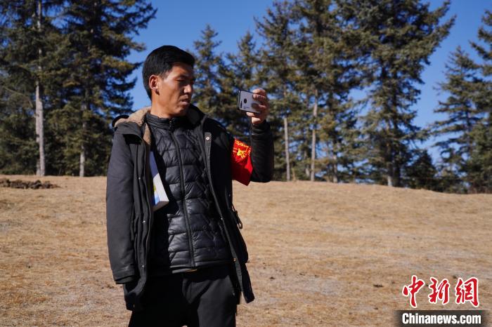 圖為桑杰加進行巡查并拍照記錄。　馬銘言 攝