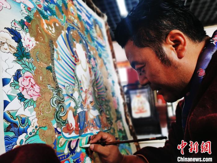 圖為久美尖措創(chuàng)作唐卡。　張?zhí)砀?攝