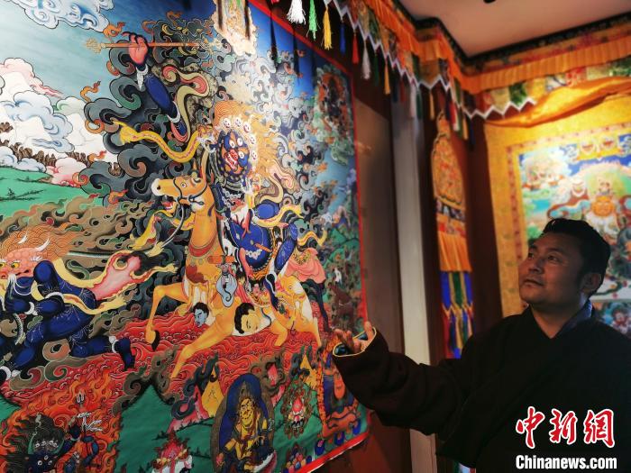 圖為久美尖措展示唐卡作品。　張?zhí)砀?攝
