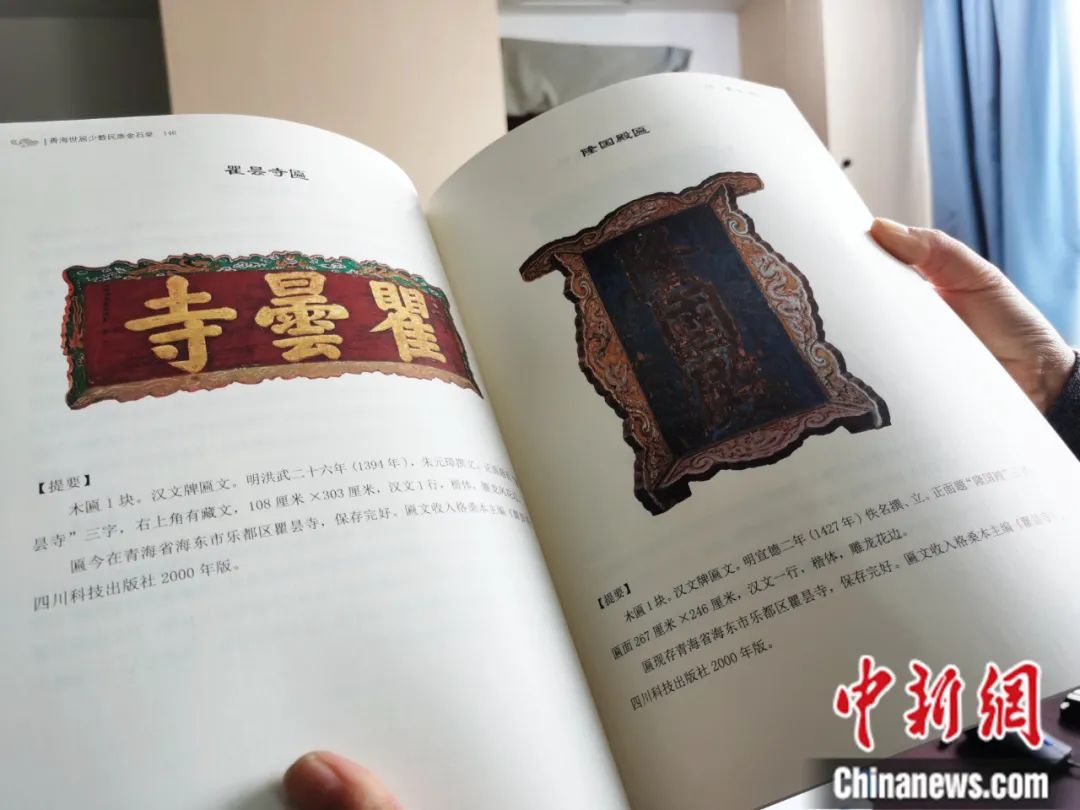 古籍保護(hù)人員展示介紹明代朱元璋撰寫的青海瞿曇寺匾(左)的出版書籍。張?zhí)砀?攝
