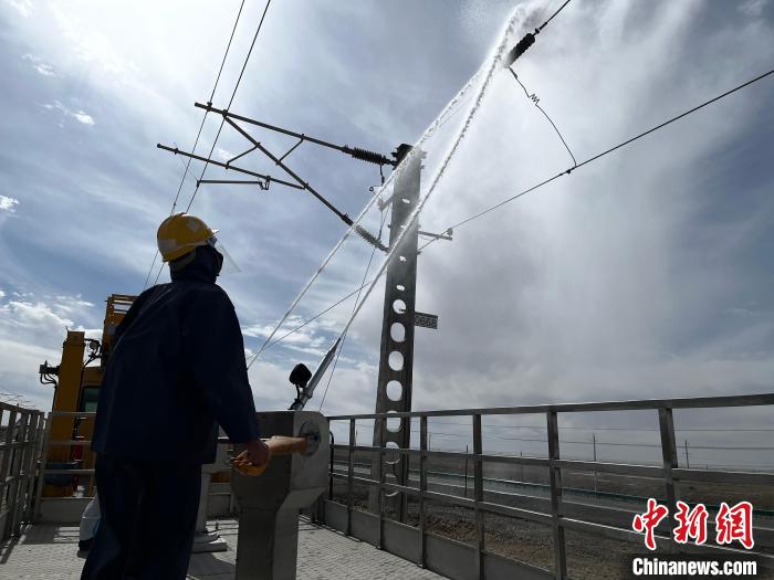 圖為高壓水槍的水柱沖洗絕緣子串?！「邌⒑?攝
