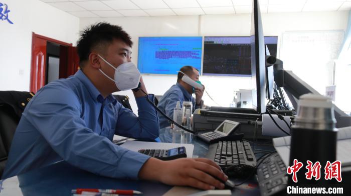 圖為貨運(yùn)調(diào)度人員與外勤工作人員聯(lián)系掌握車輛裝載情況。　李生燕 攝