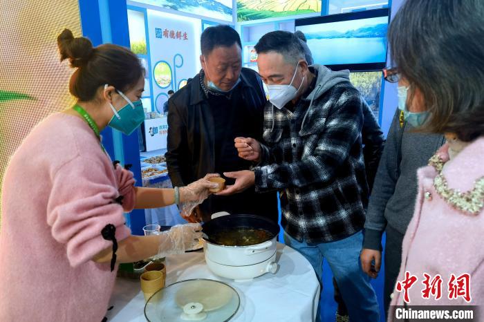 圖為杭州市民品嘗茶卡羊肉。　李雋 攝