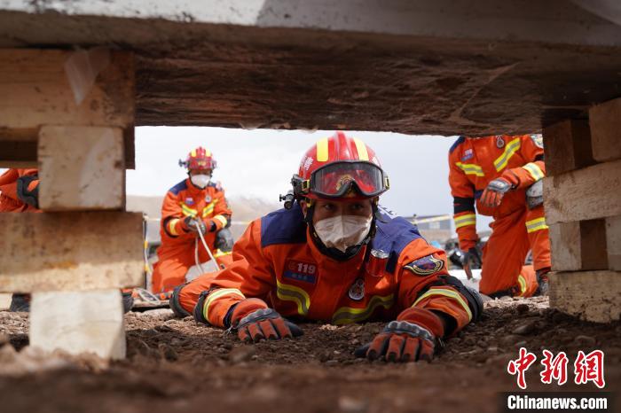 圖為地震實戰(zhàn)拉動現(xiàn)場，參演人員正在進行頂撐救援項目?！∮駱湎拦﹫D