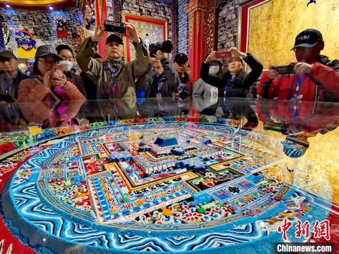 圖為參觀者拍攝壇城?！?zhí)砀?攝