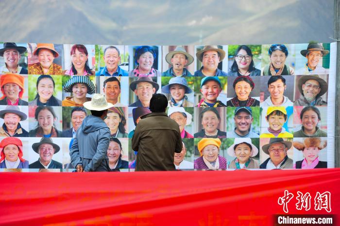 圖為當(dāng)?shù)孛癖娫谟^看展板上的笑臉?！垈?攝