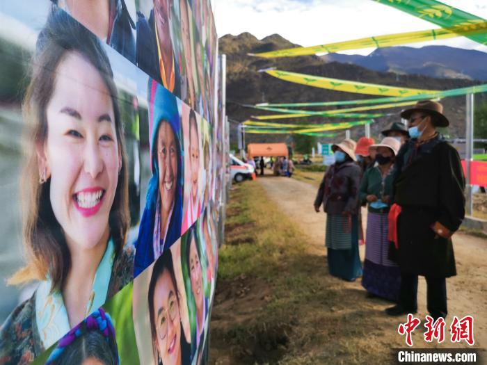 圖為當(dāng)?shù)孛癖娫谟^看展板上的笑臉?！垈?攝